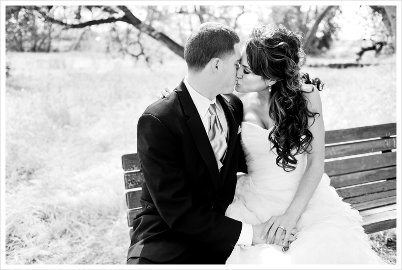 Bride and Groom kiss on a park bench at Sycamore Grove